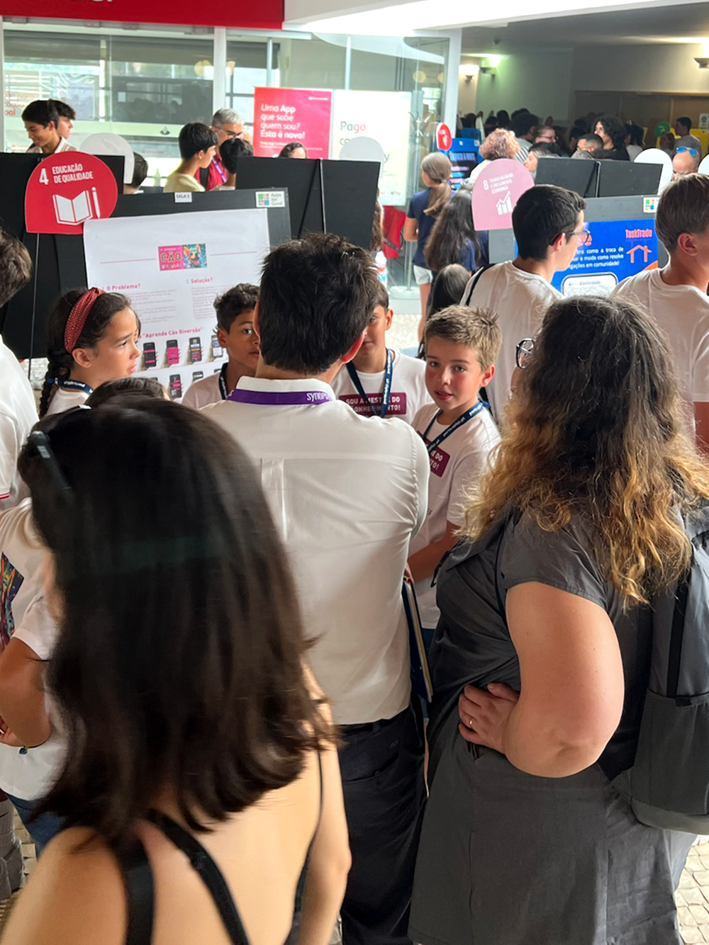 Image of children presenting their app Aprende Cao Diversao to 2 members of a Juri while all stading up. This is an image related to a project inside Pedro Rodrigues (Treze413) graphic design portfolio.